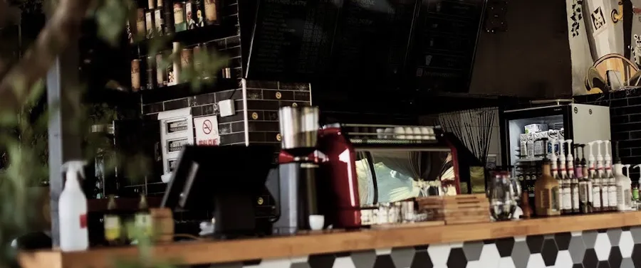 Gece tezgâh: kırmızı espresso makinesi, şurup şişesi duvarı