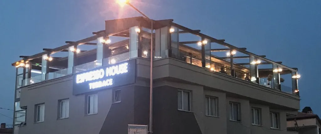 Alacakaranlıkta bina, yalnız çatı katı ışıklı